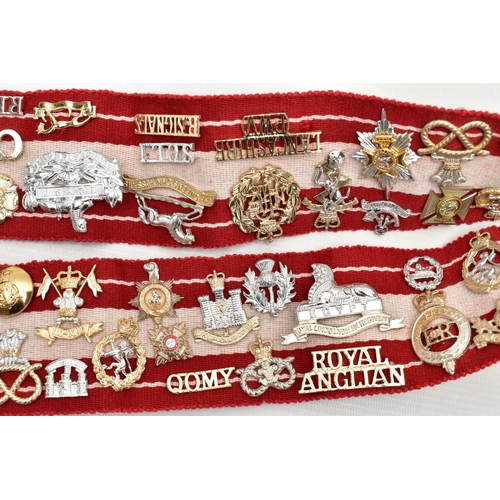 157 - A RED AND WHITE MILITARY STYLE STABLE BELT, which has had mounted over 45 Military Badges, Cap devic... 