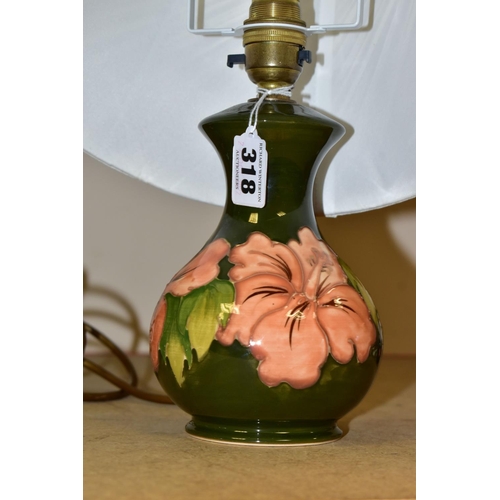 318 - A MOORCROFT TABLE LAMP, decorated in the  Coral Hibiscus pattern on a green ground with a cream shad... 