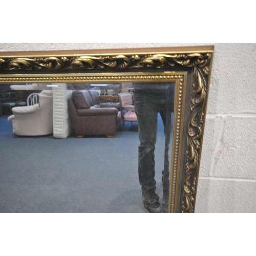 1305 - A FOLIATE GILT FRAMED BEVELLED EDGE WALL MIRROR, 131cm x 103cm