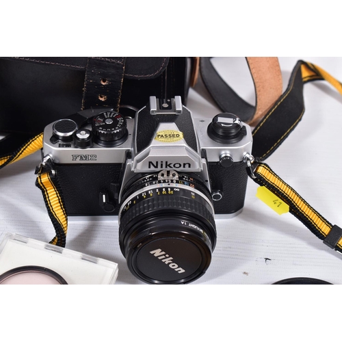 41 - A NIKON FM2 FLIM SLR CAMERA fitted with a 50mm f1.8 lens, a Nikkor 35-200mm f3.5 lens in a leather b... 