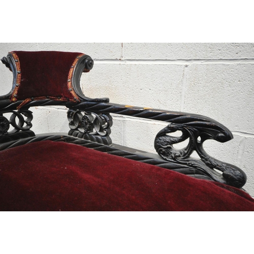 1199 - A 19TH CENTURY EBONISED CARVED WOOD SERPENTINE CHAISE LONGUE, of small proportions, having a scrolle... 