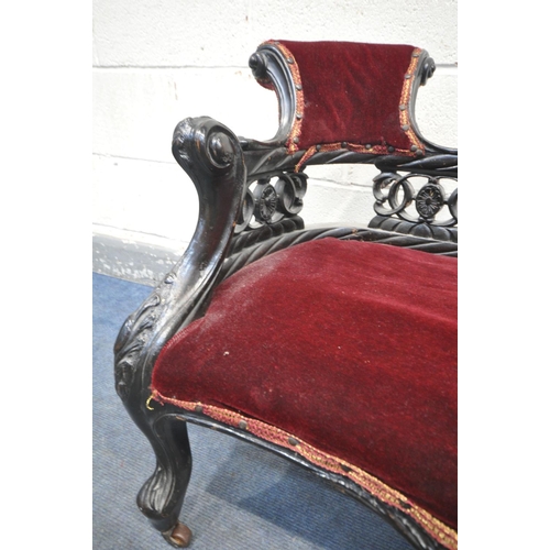 1199 - A 19TH CENTURY EBONISED CARVED WOOD SERPENTINE CHAISE LONGUE, of small proportions, having a scrolle... 