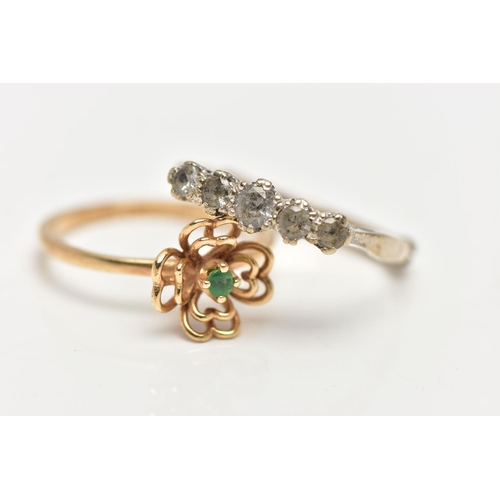 23 - TWO GEM SET RINGS, the first a designed as a small openwork flower centering on a small claw set eme... 