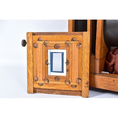 36 - A 'KING ENLARGER' MAGIC LANTERN with an oak frame and tinplate body along with two covers