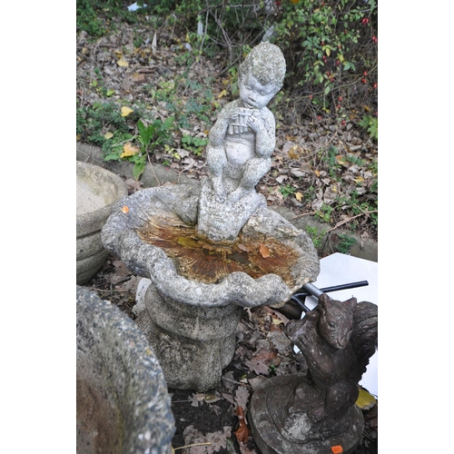 1016 - A COMPOSITE BIRD BATH in the form of a mythical figure playing pan pipes sat on an oyster shell bowl... 