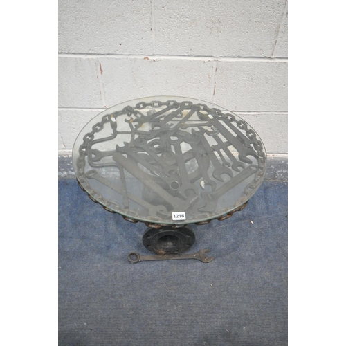 1216 - A BESPOKE OCCASIONAL TABLE, made up of mechanic tools and engine parts, with a glass top, diameter 6... 