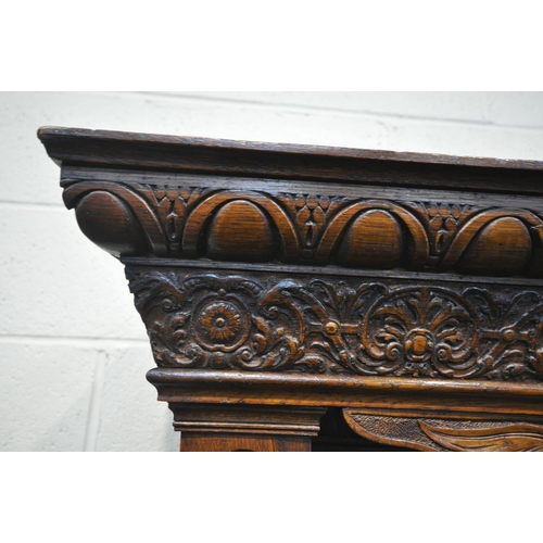 1232 - A LATE VICTORIAN SOLID OAK BUFFET, with a fixed overhanging cornice, on block supports, and five car... 