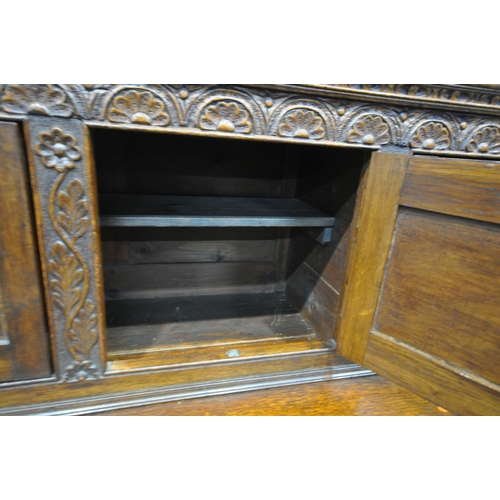 1232 - A LATE VICTORIAN SOLID OAK BUFFET, with a fixed overhanging cornice, on block supports, and five car... 