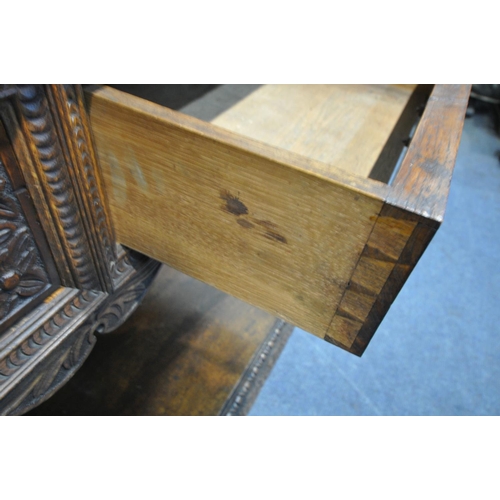 1232 - A LATE VICTORIAN SOLID OAK BUFFET, with a fixed overhanging cornice, on block supports, and five car... 