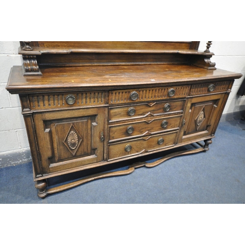 1235 - AN EARLY 20TH CENTURY OAK MIRRORBACK SIDEBOARD, with an overhanging top, supported on geometric beve... 