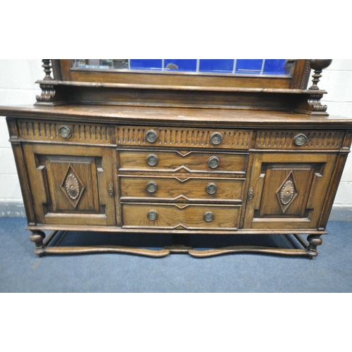 1235 - AN EARLY 20TH CENTURY OAK MIRRORBACK SIDEBOARD, with an overhanging top, supported on geometric beve... 