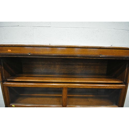 1240 - AN EARLY 20TH CENTURY OAK FOUR SECTION BOOKCASE, with twin glazed hide and fall doors, over a base w... 