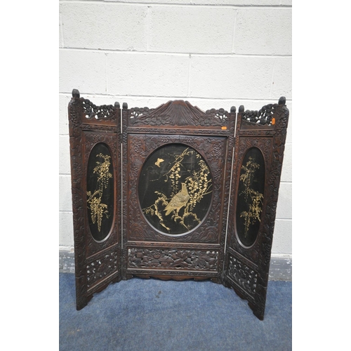 1249 - A 19TH CENTURY CARVED HARDWOOD ORIENTAL THREE FOLD FIRSCREEN, with three oval fabric chinoiserie pan... 