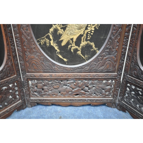 1249 - A 19TH CENTURY CARVED HARDWOOD ORIENTAL THREE FOLD FIRSCREEN, with three oval fabric chinoiserie pan... 