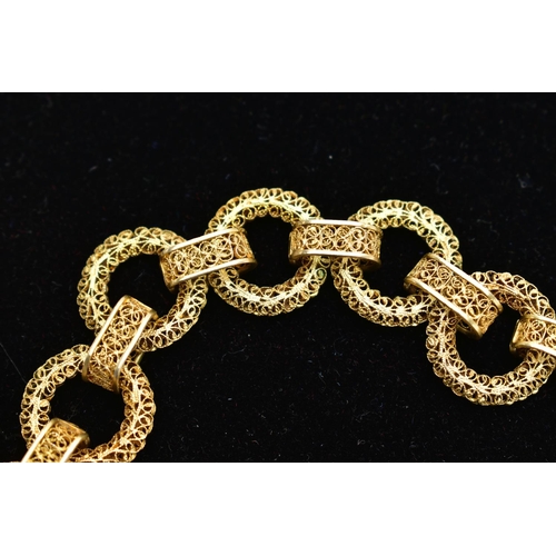 17 - A YELLOW METAL CHAIN NECKLACE, a wide chain comprised of hollow circular filagree links fitted toget... 