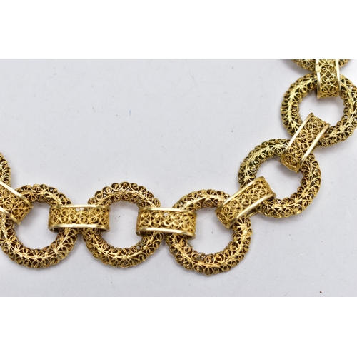 17 - A YELLOW METAL CHAIN NECKLACE, a wide chain comprised of hollow circular filagree links fitted toget... 