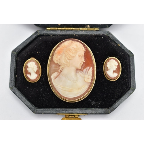 18 - A CAMEO BROOCH AND EARRING SET, a shell cameo depicting the profile of a lady facing right with a fl... 