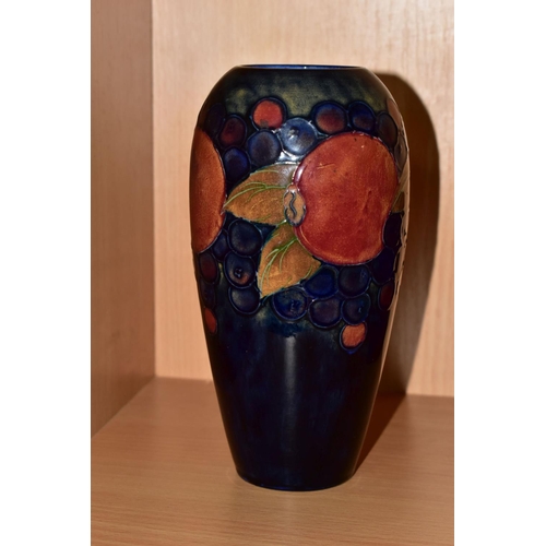 311 - A MOORCROFT POTTERY BALUSTER VASE, tube lined Pomegranate pattern on a navy blue ground, painted and... 