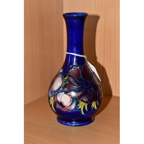 312 - A MOORCROFT POTTERY BUD VASE, tube lined pink and purple Anemone pattern on a blue ground, impressed... 