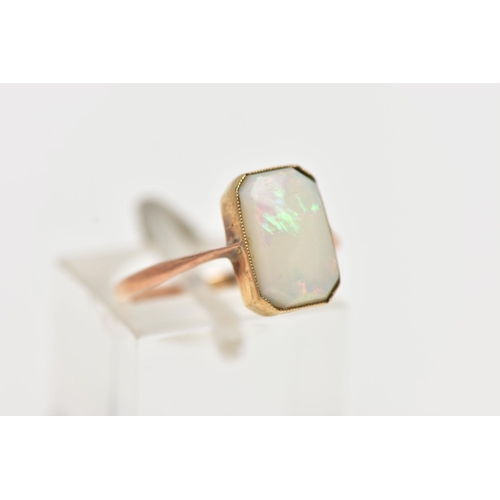 46 - A YELLOW METAL OPAL RING, rectangular cut opal cabochon with cut off corners, milgrain collet mount,... 