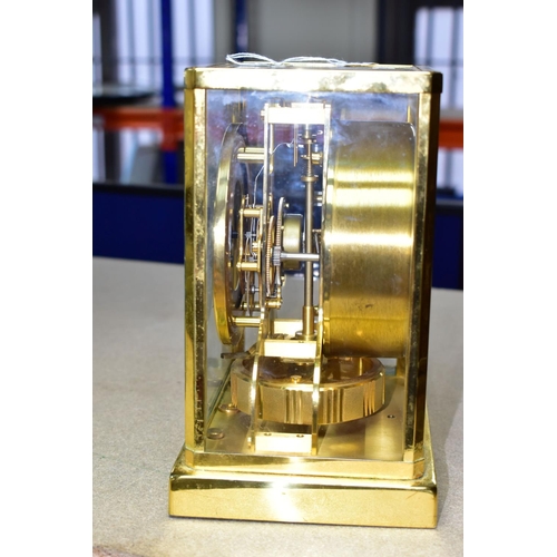 353 - AN ATMOS JAEGER-LECOULTRE  SWISS MADE MANTEL CLOCK, in a rectangular brass and glass case, cream cha... 