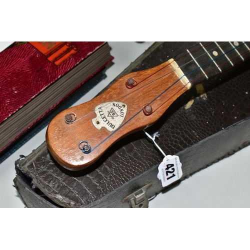 421 - A BARNETT SAMUEL DULCETTA UKULELE BANJO IN DISTRESSED CASE, the banjo has four tuning keys, total ap... 