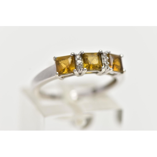 30 - A WHITE GOLD GEM SET RING, set with three square cut yellowish/green stones, interspaced with single... 