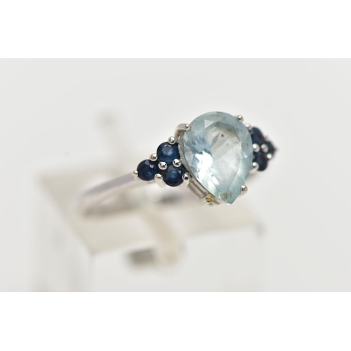 31 - A 9CT WHITE GOLD GEM SET RING, set with a pear cut aquamarine, flanked each side with three circular... 