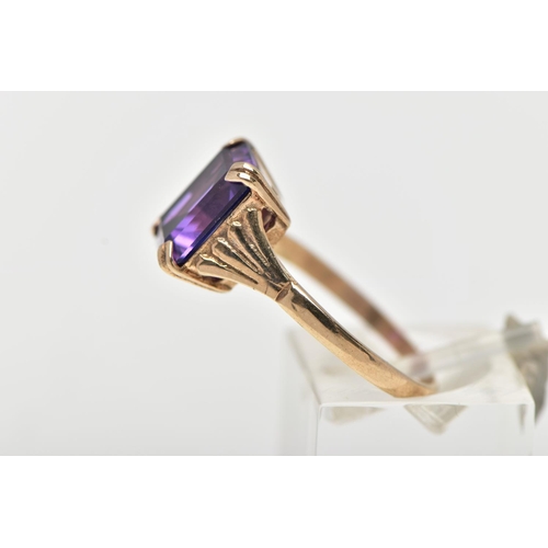 70 - A 9CT GOLD AMETHYST RING, featuring a double four claw set, rectangular cut amethyst, raised openwor... 