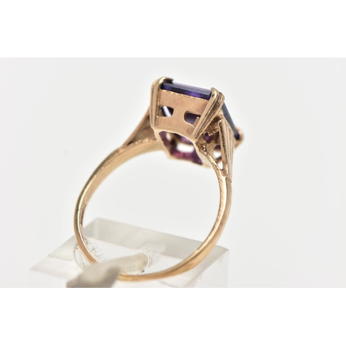 70 - A 9CT GOLD AMETHYST RING, featuring a double four claw set, rectangular cut amethyst, raised openwor... 