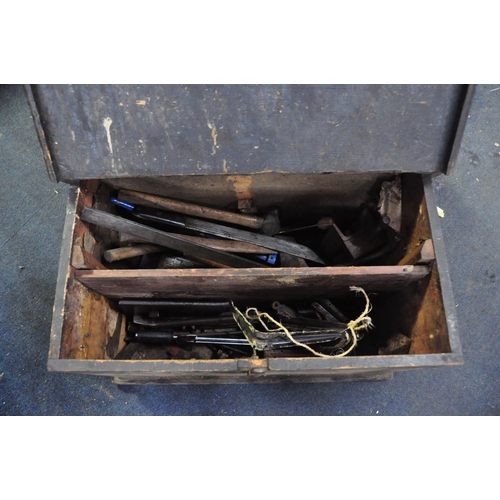 1091 - A VINTAGE WOODEN CHEST containing vintage tools, pry bars, brackets, large hammers, clamps etc. alon... 