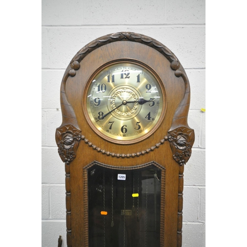 1205 - AN EARLY 20TH CENTURY OAK LONGCASE CLOCK, with a rounded top, single long glazed door enclosing a br... 