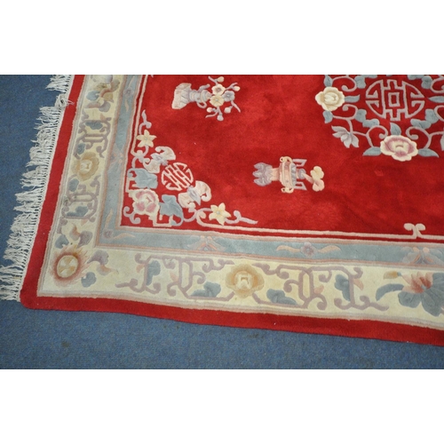 1221 - A RED GROUND WOOLEN RUG, with a multi strap border, and a central floral design 276cm x 190cm (condi... 