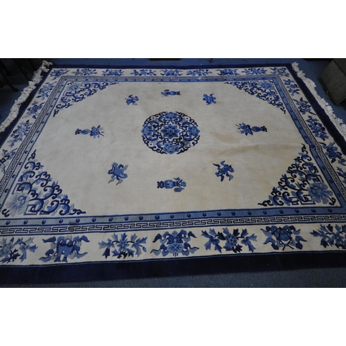 1266 - A CHINESE CREAM AND BLUE WOOLLEN CARPET, 370cm x 275cm (condition:-in need of cleaning)