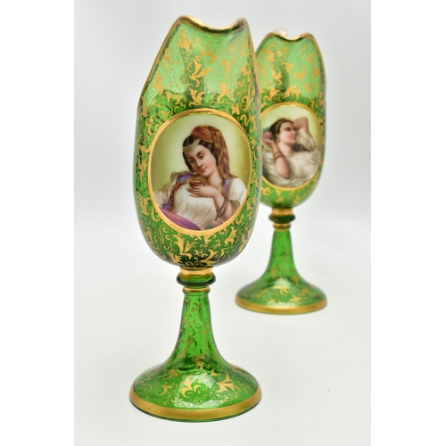 106 - A PAIR OF 19TH CENTURY BOHEMIAN GREEN AND GILT GLASS PEDESTAL EWERS OF HELMET FORM, each with a whit... 