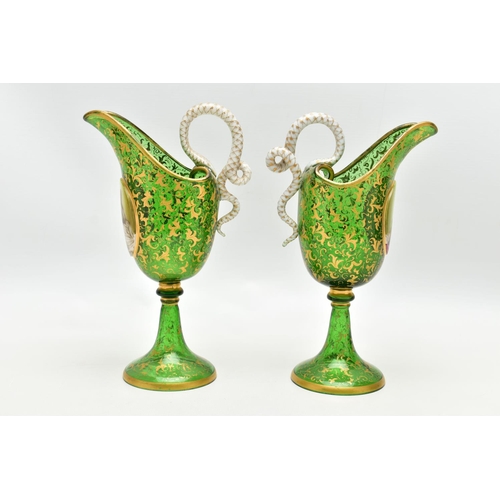 106 - A PAIR OF 19TH CENTURY BOHEMIAN GREEN AND GILT GLASS PEDESTAL EWERS OF HELMET FORM, each with a whit... 