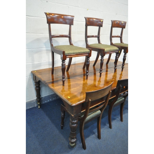 227 - A REGENCY FLAME MAHOGANY DINING TABLE, on eight turned legs with large brass caps and casters, break... 