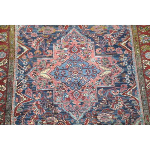 249 - A KASHAN STYLE BLUE GROUND RUG, with a foliate multistrap border, with a central medallion 203cm x 1... 