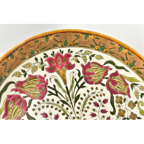 112 - A ZSOLNAY PECS POTTERY POLYCHROME ENAMELLED CHARGER, ochre rim surrounding a rough textured gilt and... 