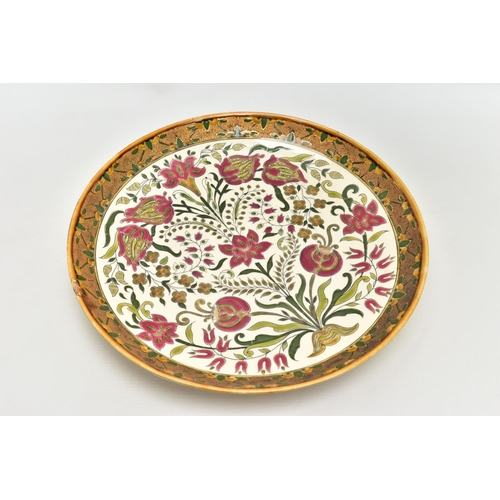 112 - A ZSOLNAY PECS POTTERY POLYCHROME ENAMELLED CHARGER, ochre rim surrounding a rough textured gilt and... 