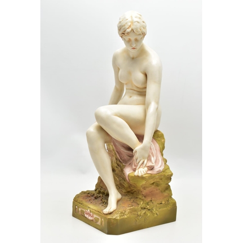 125 - AN EARLY 20TH CENTURY ROYAL DUX FIGURE OF A SEATED NUDE FEMALE BATHER, modelled on a rocky outcrop d... 