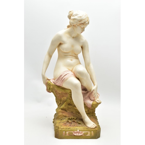 125 - AN EARLY 20TH CENTURY ROYAL DUX FIGURE OF A SEATED NUDE FEMALE BATHER, modelled on a rocky outcrop d... 