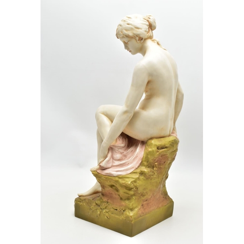 125 - AN EARLY 20TH CENTURY ROYAL DUX FIGURE OF A SEATED NUDE FEMALE BATHER, modelled on a rocky outcrop d... 