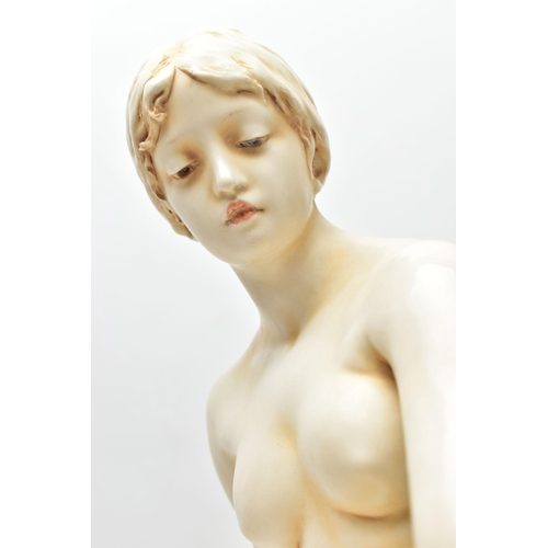 125 - AN EARLY 20TH CENTURY ROYAL DUX FIGURE OF A SEATED NUDE FEMALE BATHER, modelled on a rocky outcrop d... 