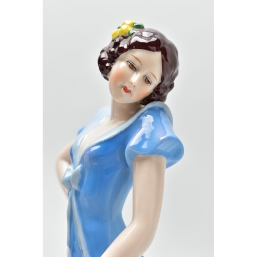 149 - A 1930'S CONTINENTAL PORCELAIN FIGURE OF A LADY IN A LONG BLUE DRESS, modelled standing on an oval b... 