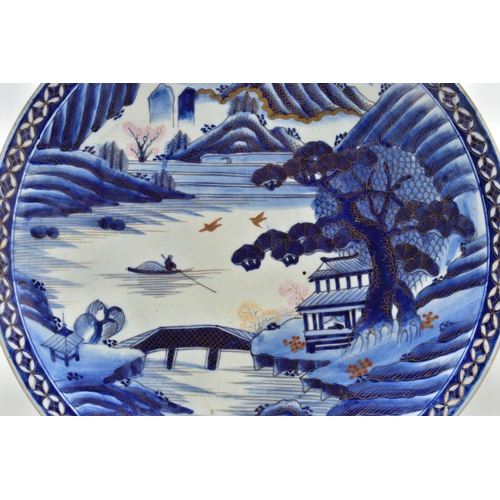 153 - A 19TH CENTURY JAPANESE PORCELAIN CHARGER, primarily painted in underglaze blue with a mountainous l... 