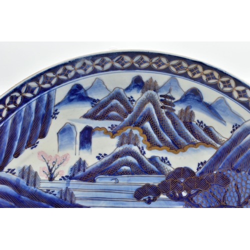 153 - A 19TH CENTURY JAPANESE PORCELAIN CHARGER, primarily painted in underglaze blue with a mountainous l... 