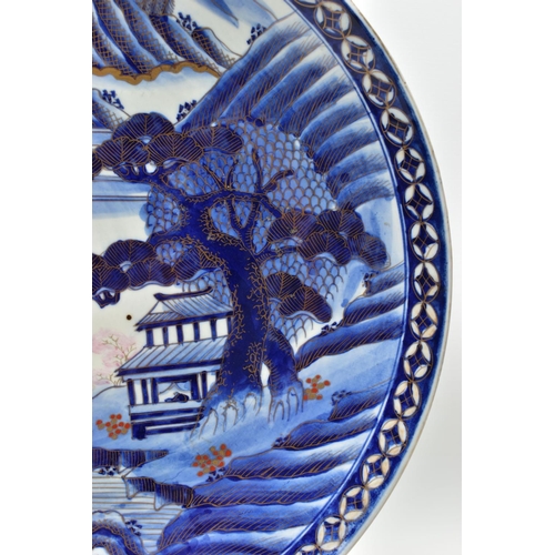 153 - A 19TH CENTURY JAPANESE PORCELAIN CHARGER, primarily painted in underglaze blue with a mountainous l... 