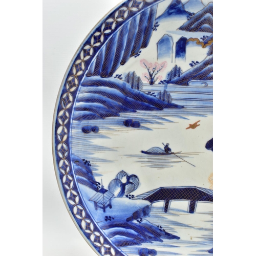 153 - A 19TH CENTURY JAPANESE PORCELAIN CHARGER, primarily painted in underglaze blue with a mountainous l... 