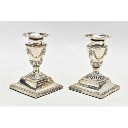 64 - A PAIR OF LATE VICTORIAN SILVER DWARF CANDLESTICKS, beaded rims throughout, the urn shaped candlehol... 